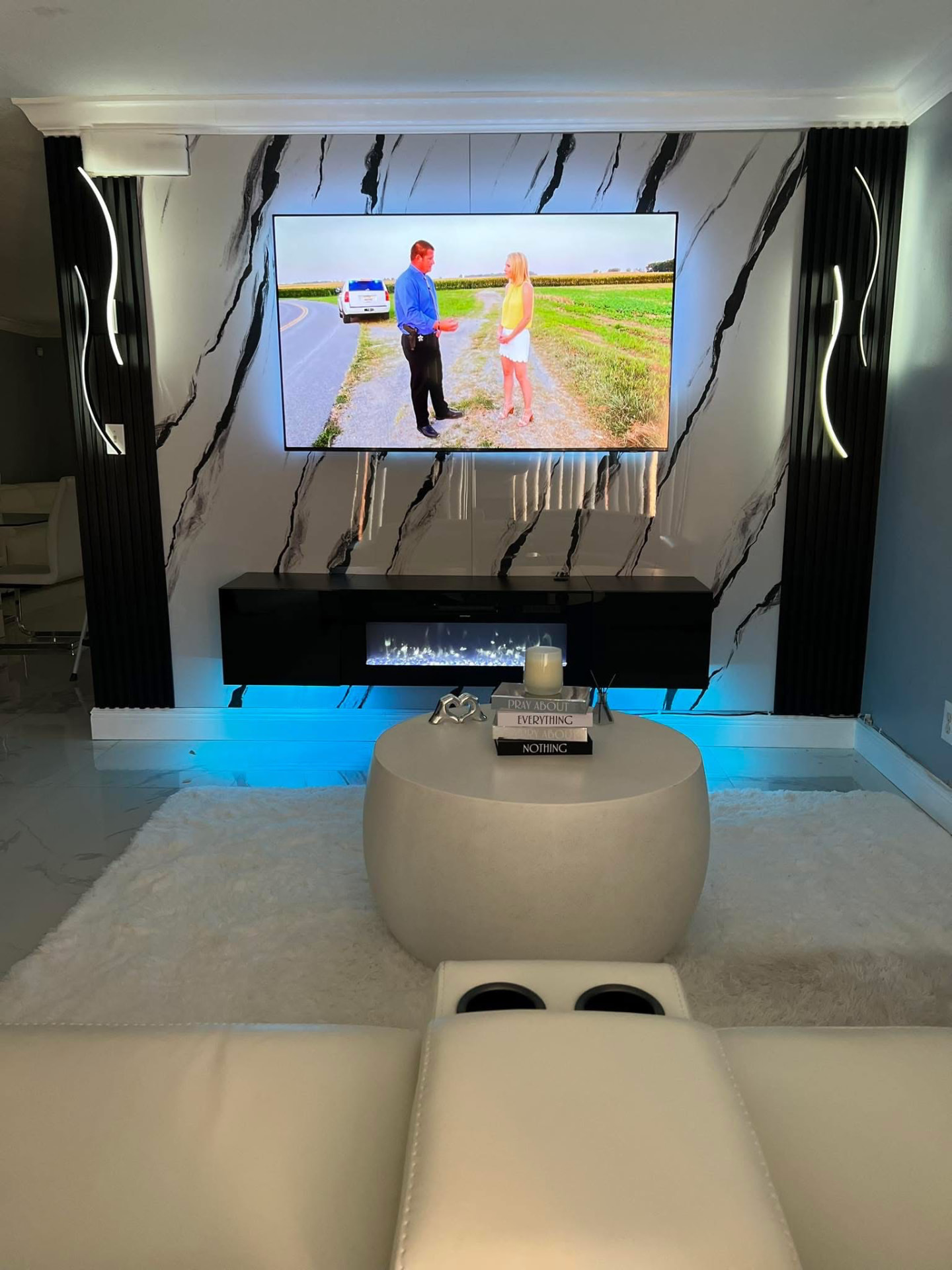 Marble entertainment wall with LED accent lighting, floating console and fireplace